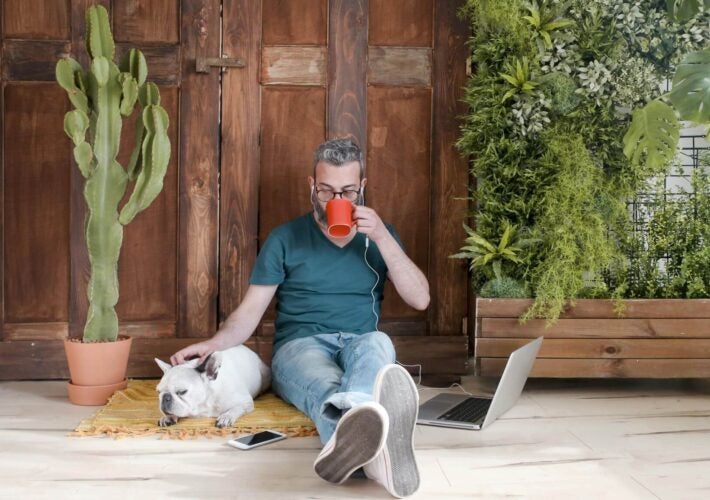 Man sitting with dog and plants