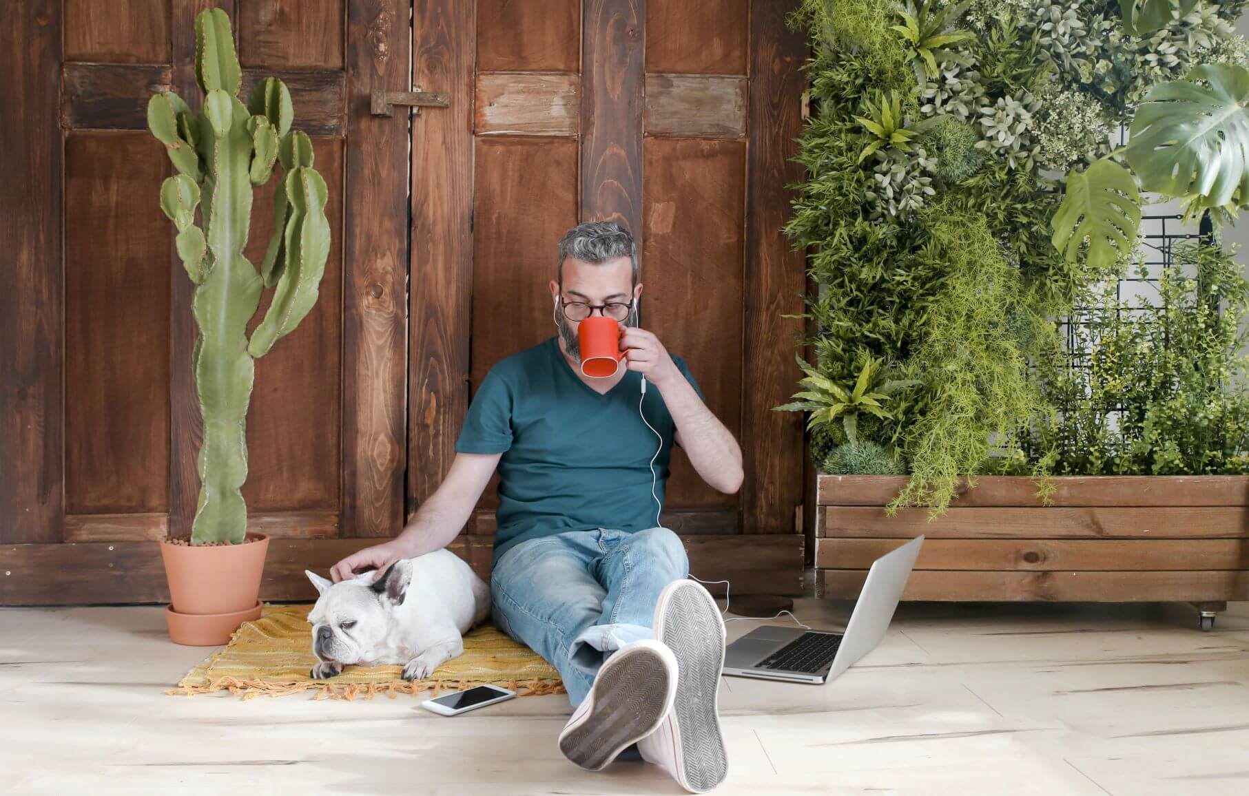 Man sitting with dog and plants
