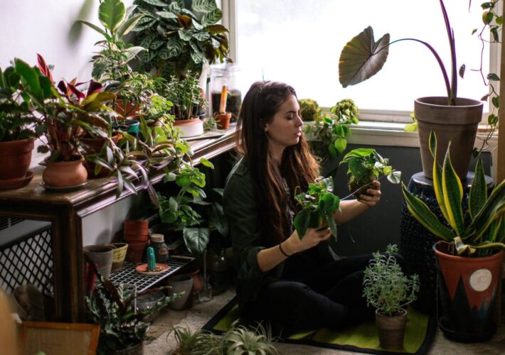 woman sitting on floor with plants