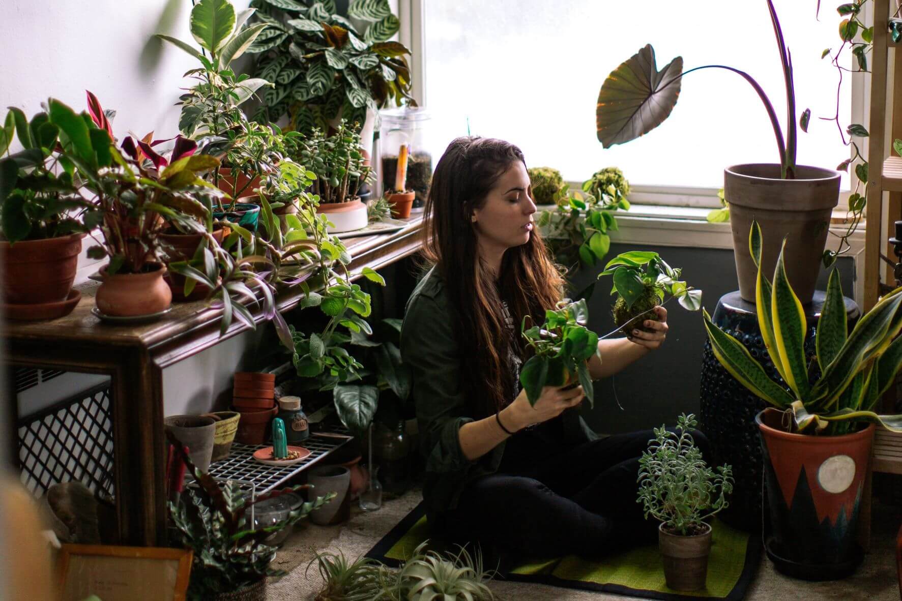 woman sitting on floor with plants